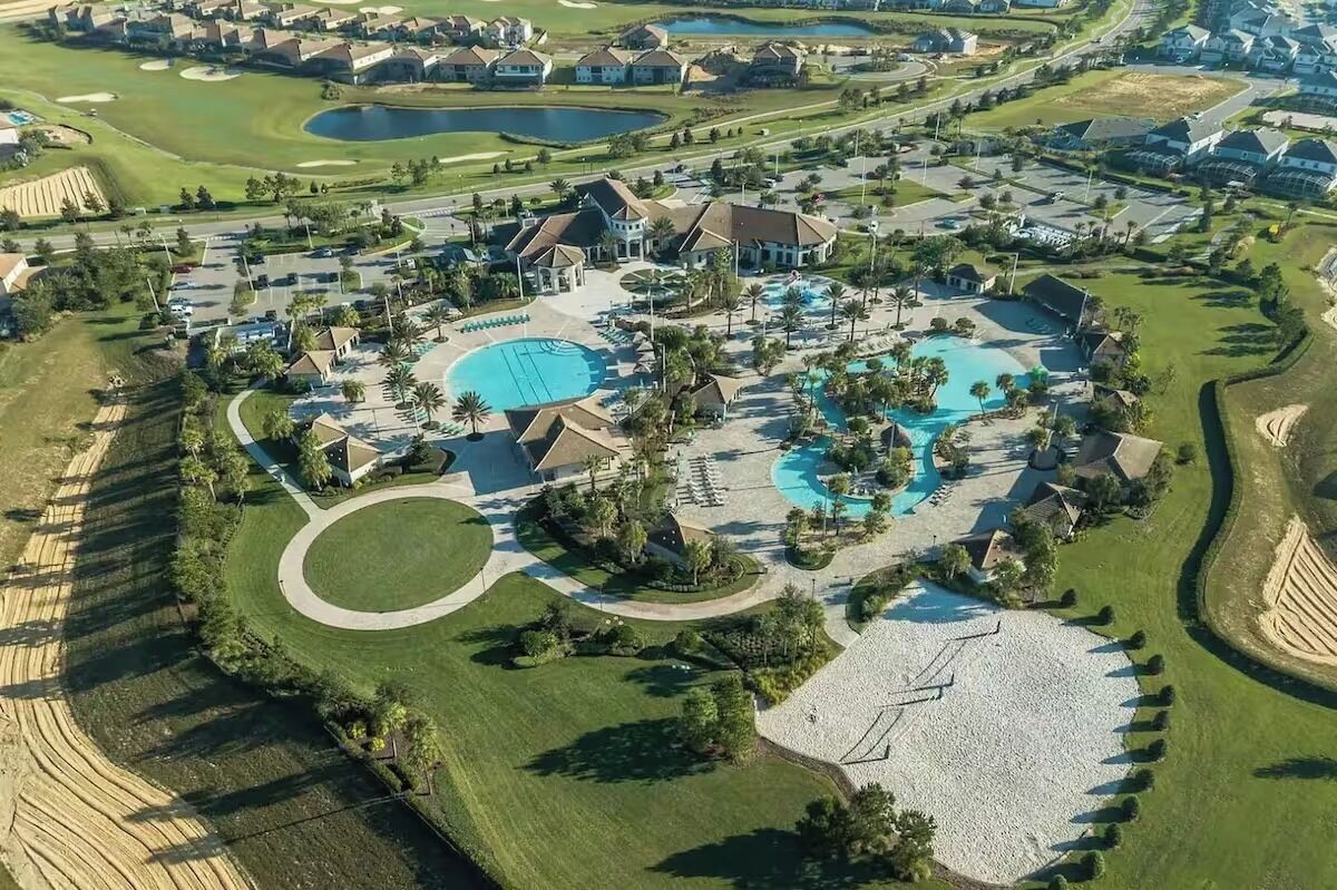 An aerial view of a resort with multiple swimming pools, golf courses, and residential buildings.
