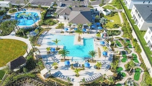 Vue aérienne d’un complexe hôtelier doté de plusieurs piscines, de chaises longues et d’un parcours de golf.