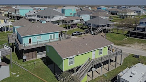 A coastal residential area with multiple two-story houses, some with attached decks and a few with elevated walkways. - Lime In The Coconut 3 Bedroom Home (Port Bolivar)