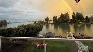 A lake with a rainbow, a hot air balloon, and a view of a dock and greenery. - The Green Heaven at the Lake (Lake Tapps)