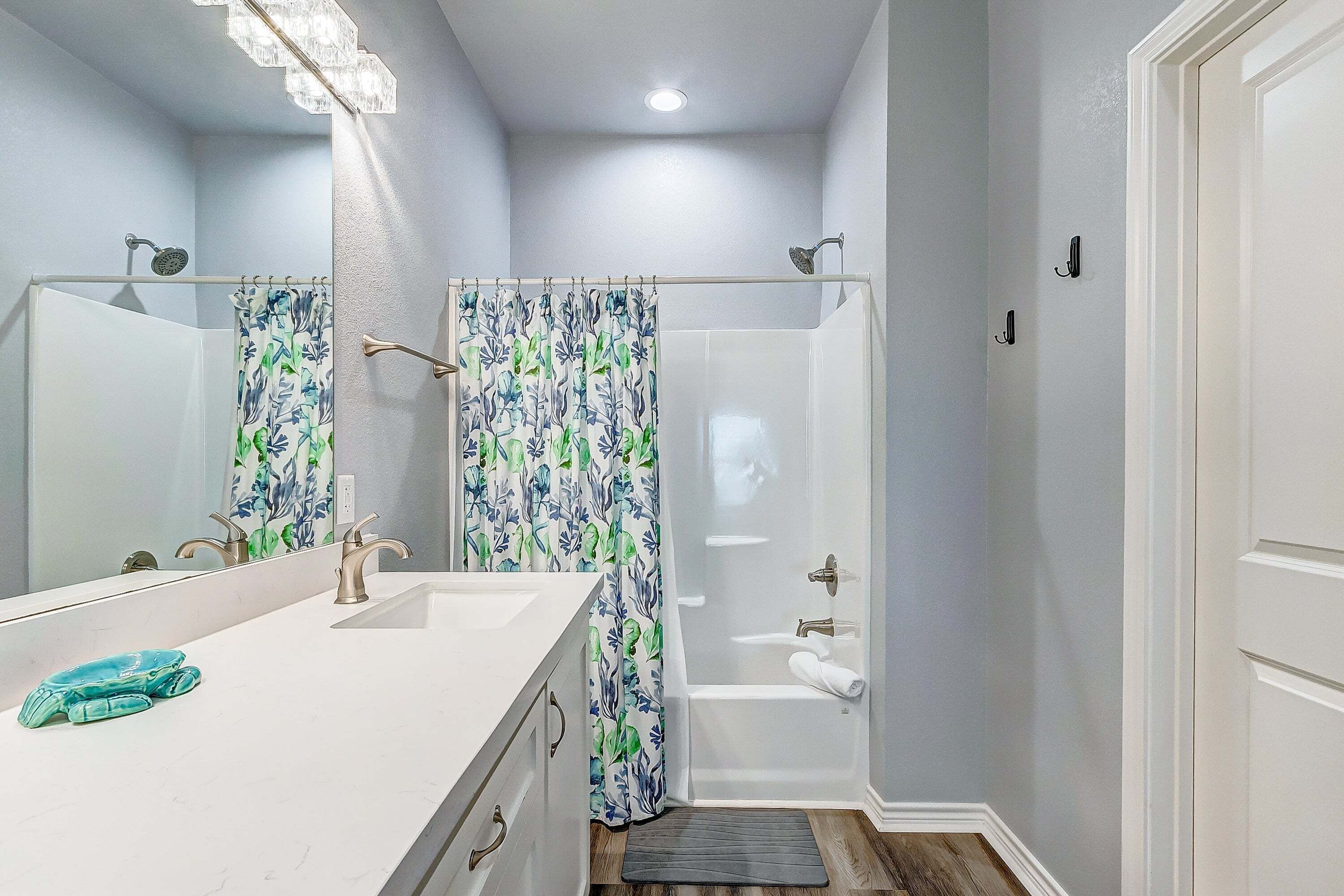 Une salle de bain avec une douche, un lavabo et un miroir.