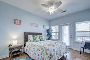 A bedroom with a bed, a ceiling fan, a nightstand, a potted plant, and a window with blinds. - Oceanview 4 Bedroom Home (Port Bolivar)