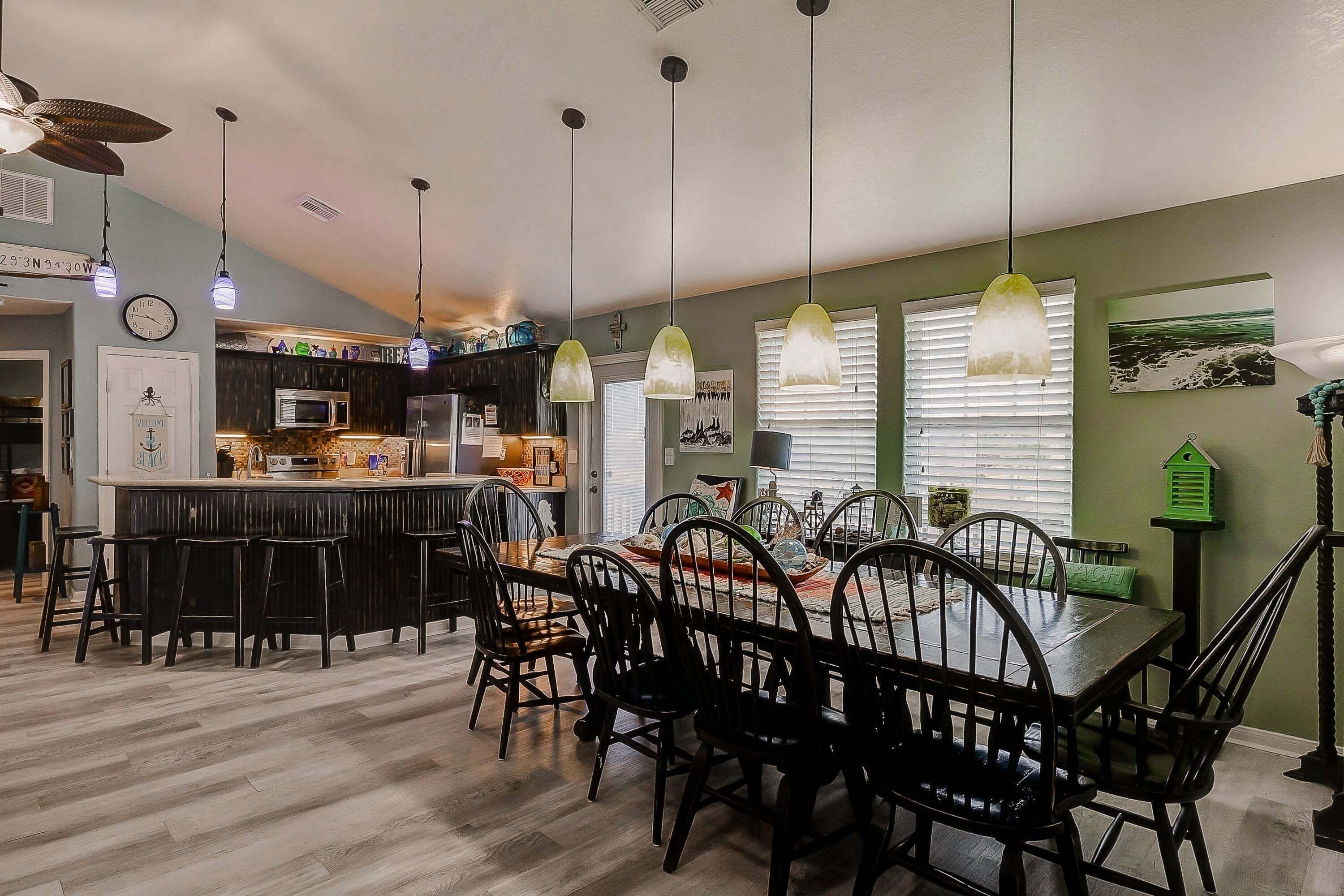 A modern kitchen with a central island, bar seating, and pendant lighting.