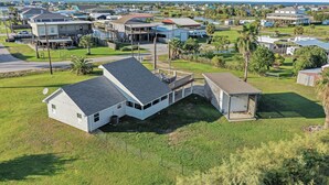 A residential area with houses, a dock, and a grassy field. - Over The Rainbow 3 Bedroom Home (Port Bolivar)