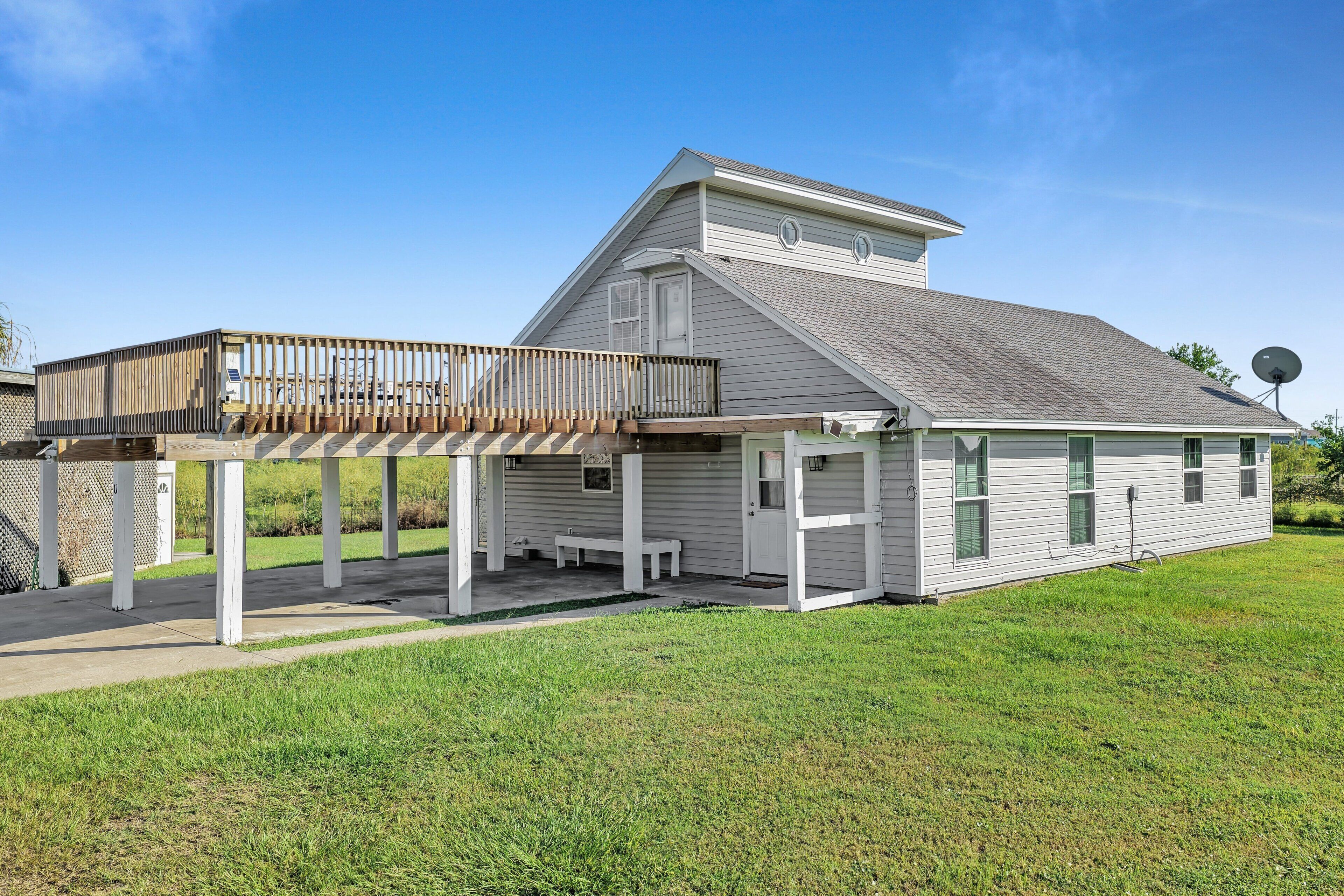 A single-story house with a covered patio, a satellite dish, and a small porch.