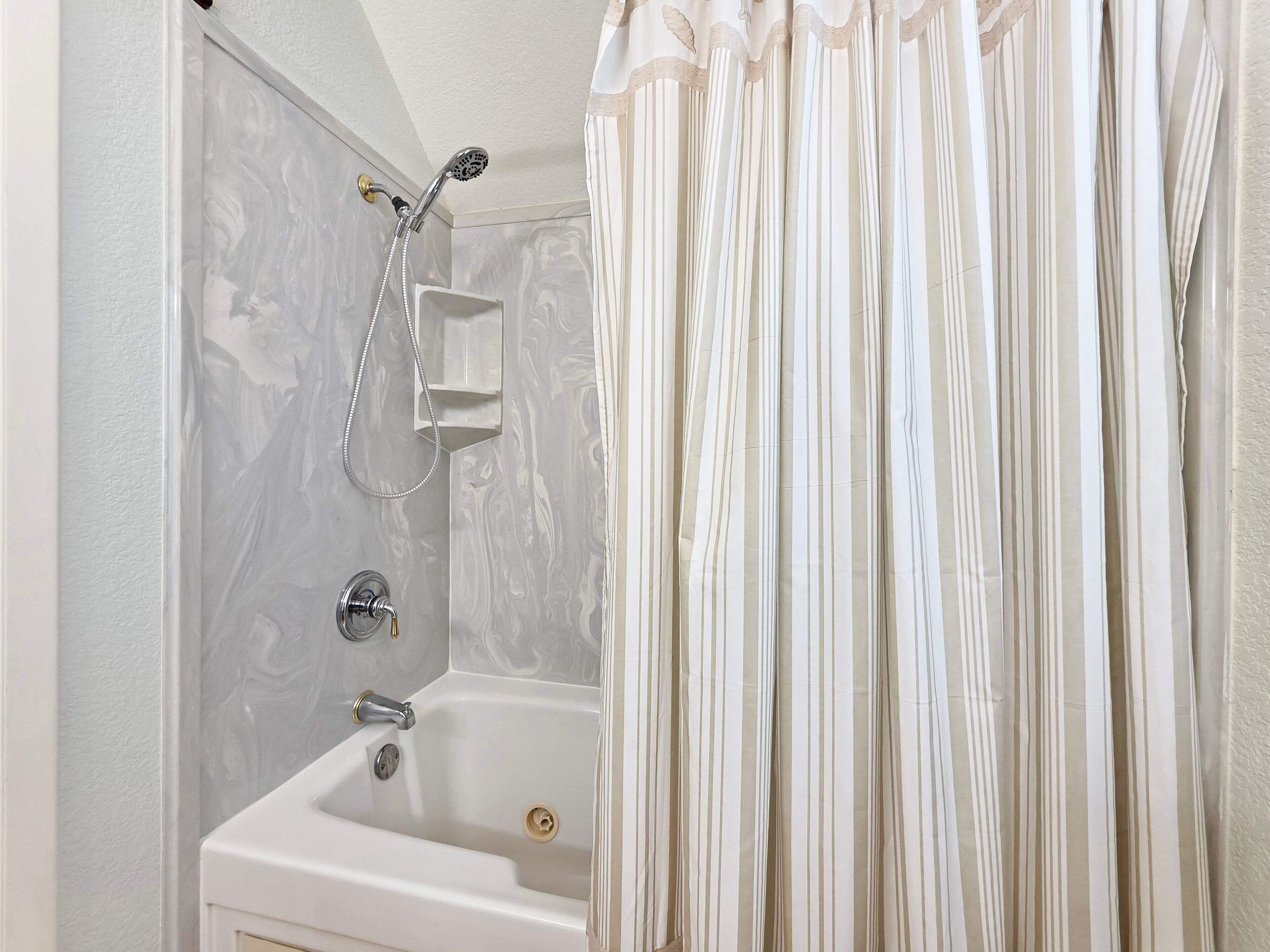 A bathroom with a shower, a bathtub, and a toilet.