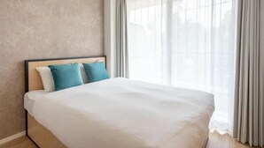 Ein Hotelzimmer mit einem Bett, Vorhängen und einem Fenster.