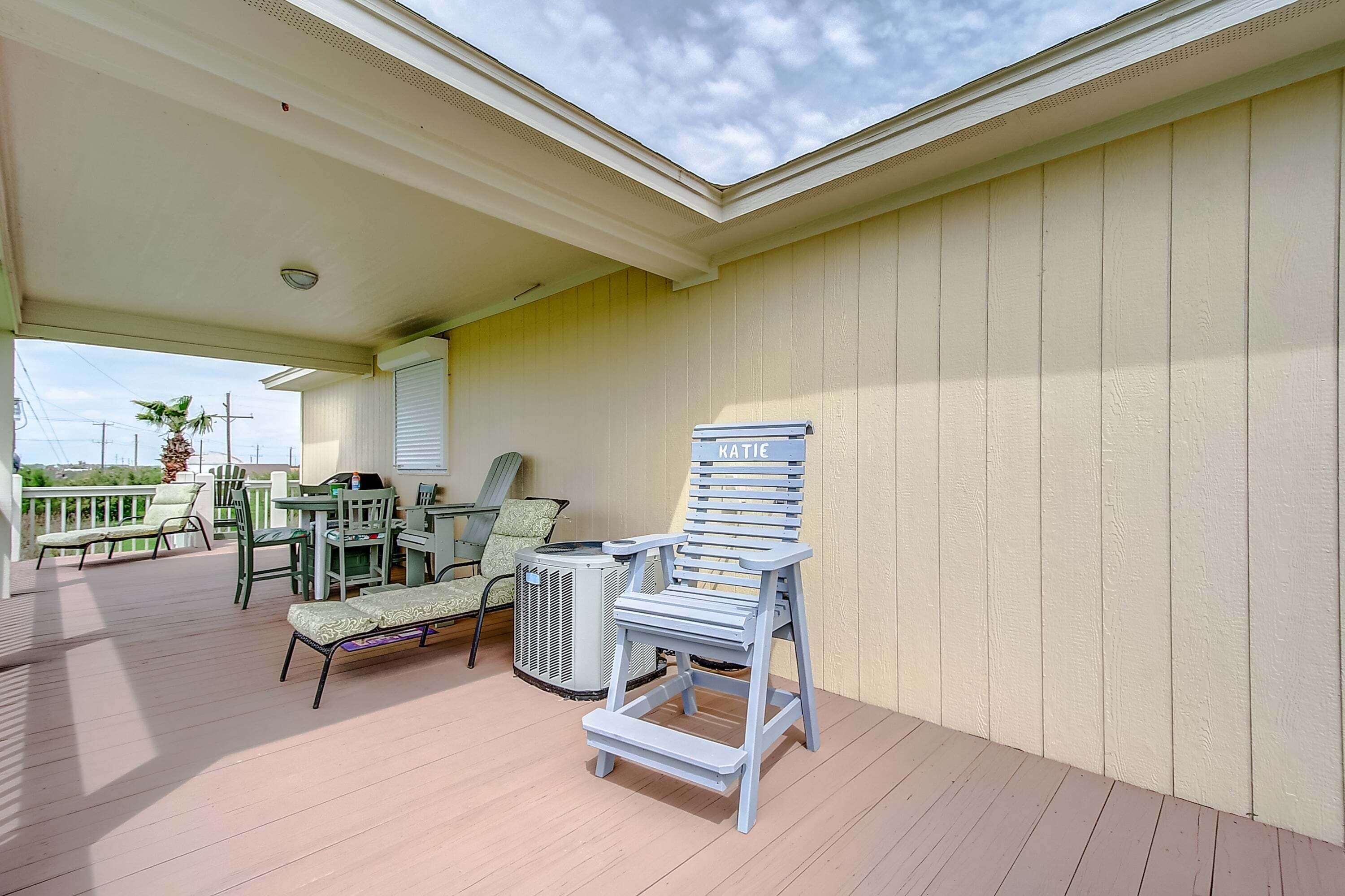 A covered outdoor area with a table and chairs, a step-up chair, and a ceiling fan.