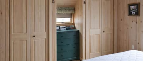 A bedroom with a bed, a dresser, and two wardrobes.