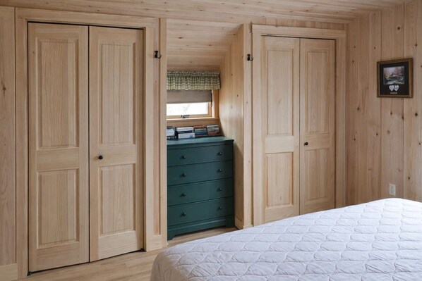 A bedroom with a bed, a dresser, and two wardrobes.