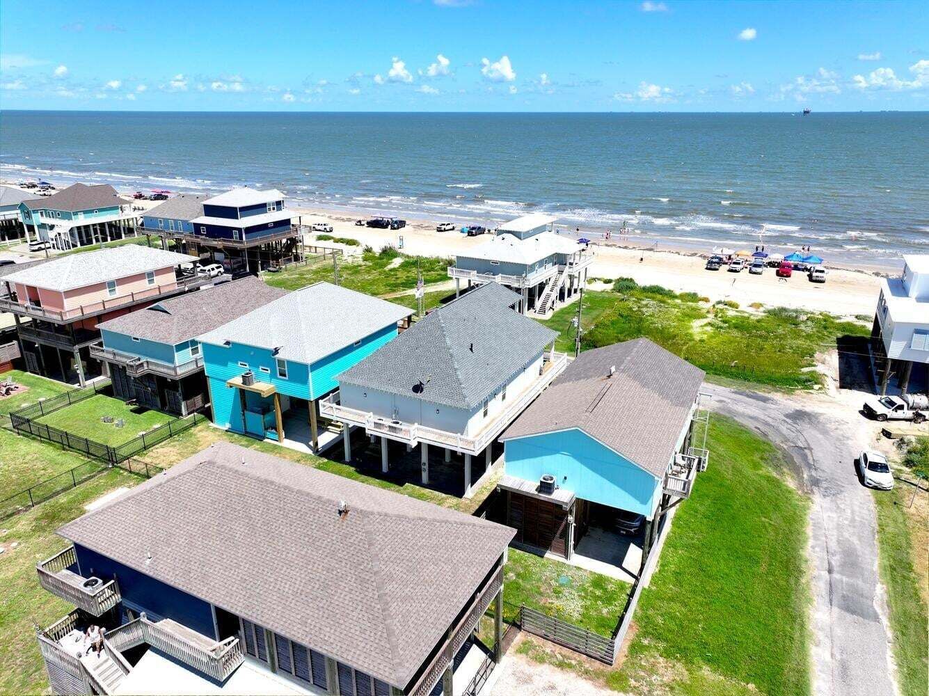A coastal residential area with houses, a beach, and a view of the ocean.
