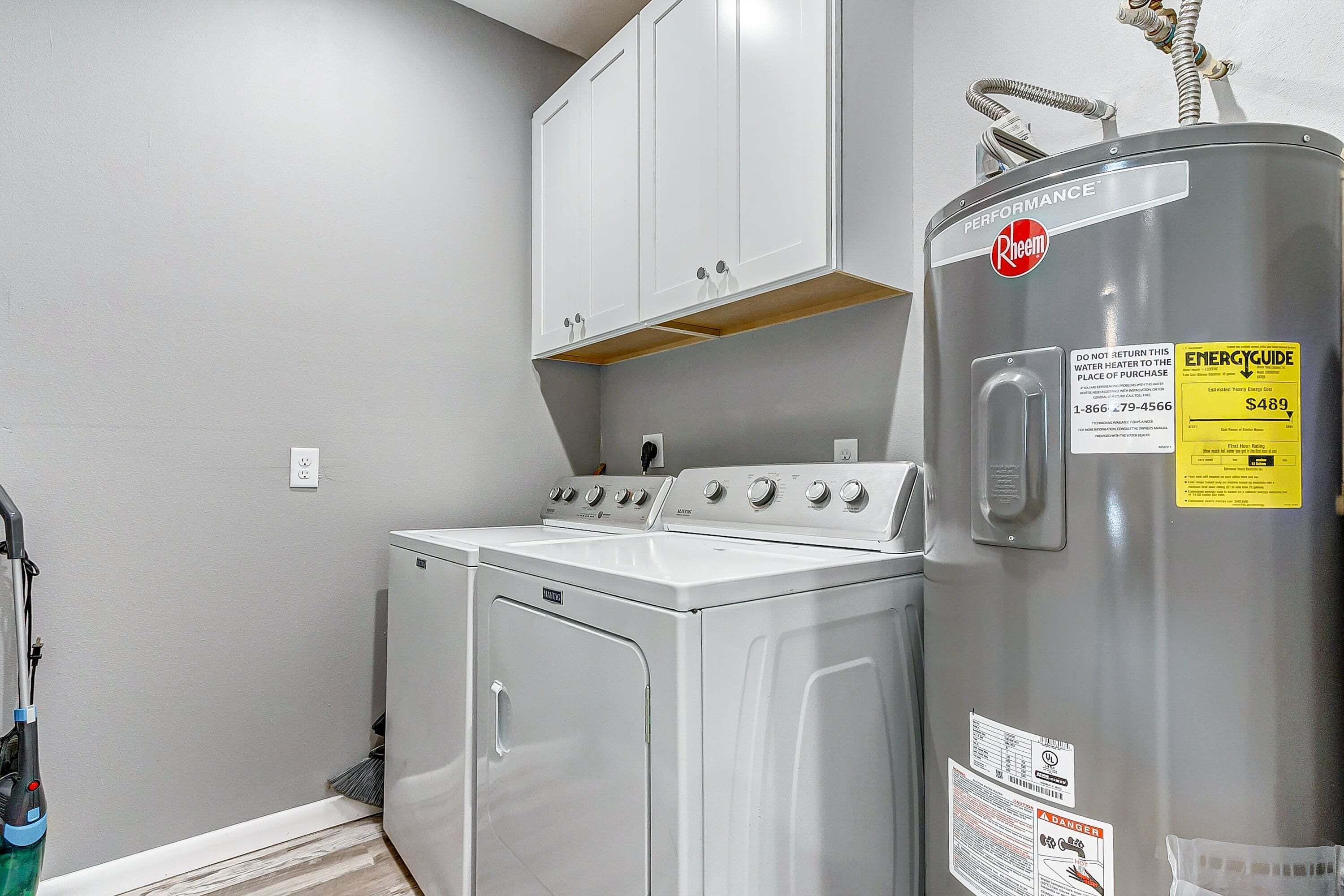 A laundry room with a washer, dryer, and a water heater.