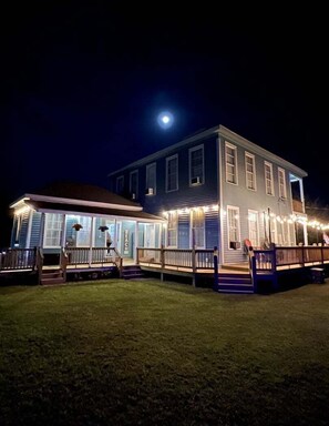 A two-story building with a covered porch and a visible sign that reads 'BEACH'. - Shiloh By The Sea 5 Bedroom Home (Port Bolivar)
