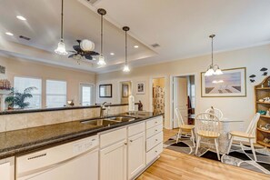 A kitchen with a central island, pendant lights, and a ceiling fan. - Sharkyfin's Ii 3 Bedroom Home (Port Bolivar)