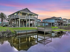 A waterfront property with a large house featuring multiple decks and a covered patio area. - Turtle Beach 3 Bedroom Home (Port Bolivar)