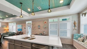 A kitchen with a central island, stainless steel appliances, and a teal ceiling. - Turtle Beach 3 Bedroom Home (Port Bolivar)