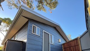 A modern house with a front door, a small porch, and a wooden fence.