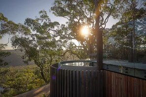 Un espacio exterior moderno con una estructura circular, rodeado de árboles y un cielo despejado.