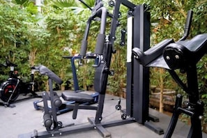 A gym with exercise equipment, a bench, and a stationary bike.