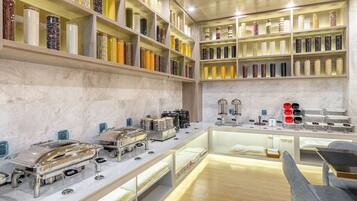 A well-lit room with shelves of jars, a buffet setup, and a seating area.