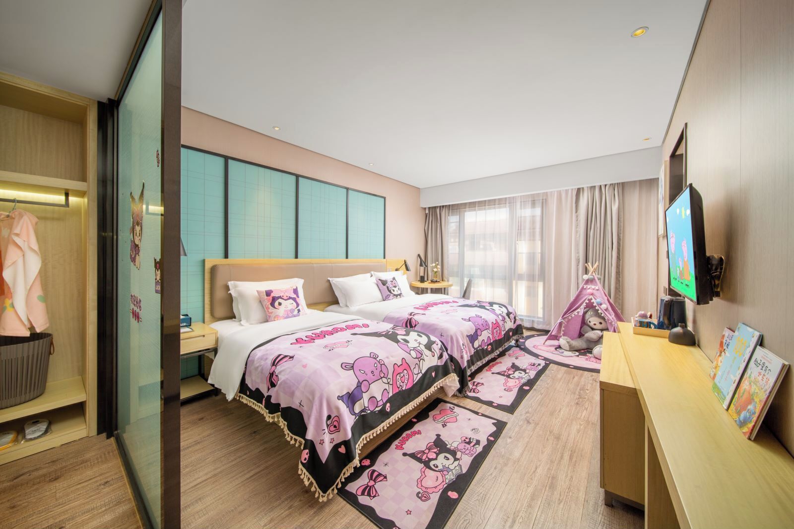A hotel room with two beds, a TV, a desk, and a wardrobe.