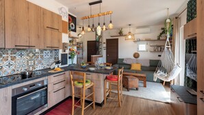 Una cucina moderna con mobili in legno, un'isola centrale e illuminazione a sospensione.