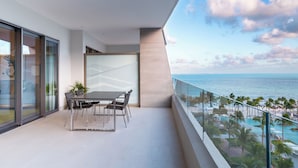 A modern balcony with a dining table and chairs, overlooking a pool and beach area. - Confirmed Reservation in Cancun!Thanksgiving Week!   (Cancún)