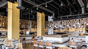 A modern restaurant with high ceilings, exposed ductwork, and a central seating area with tables and chairs. - Confirmed Reservation in Cancun!Thanksgiving Week!   (Cancún)