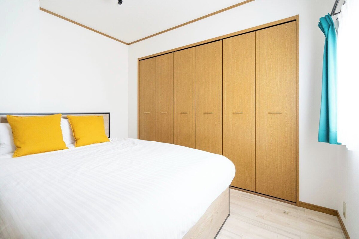 A bedroom with a bed, a wardrobe, and a curtain.