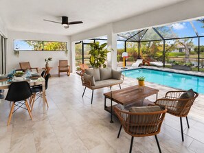Un vaste espace intérieur comprenant une piscine, un coin repas et des sièges.