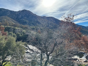 Eine gebirgige Landschaft mit blauem Himmel, felsigem Gelände und vereinzelter Vegetation.