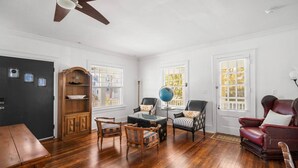A room with hardwood flooring, a wooden cabinet, a globe, two chairs, a red leather armchair, and a dining table. - 9BR Sleeps 19 - 1 Block to Beach - Ocean Views! (Ventnor City)