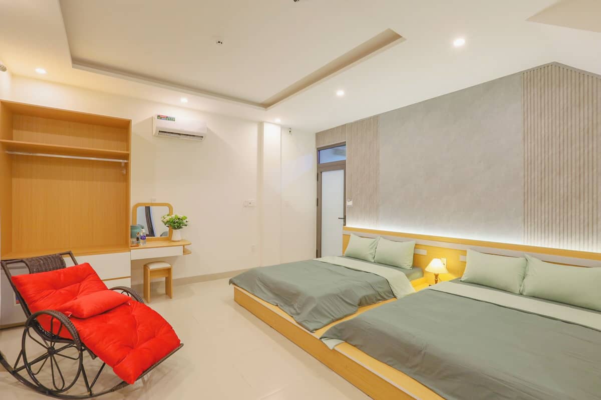 Un dormitorio moderno con cama, silla, escritorio y armario.