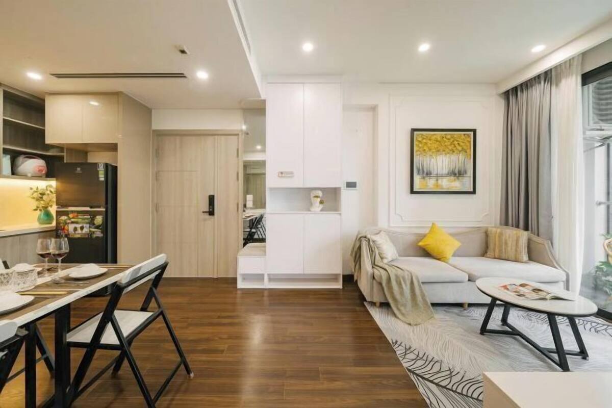 A modern living room with a sofa, coffee table, and dining area with chairs.