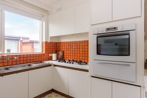 Oven, stovetop, toaster, dining tables - Retro 3BR Mid Century Apartment (St Kilda East)