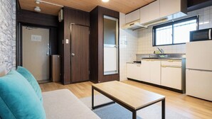 Una cocina compacta con zona de comedor, techo de madera y una pequeña mesa.
