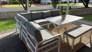 A covered outdoor seating area with a sectional sofa, a table, and chairs. - Villa Quindy - ideally located a short 2 minute stroll to Quindalup bay beach. (Quindalup)