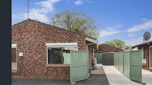 A brick house with a satellite dish, a window, and a gated driveway. - Villa Quindy - ideally located a short 2 minute stroll to Quindalup bay beach. (Quindalup)