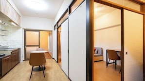 Een moderne hotelkamer met een kitchenette, een eettafel en een aparte zithoek.