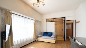 Een moderne woonkamer met een bank, een flatscreen-tv en een eethoek.