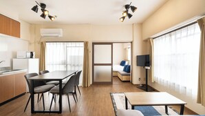 Een hotelkamer met een eethoek, een bank, een televisie en een bed.