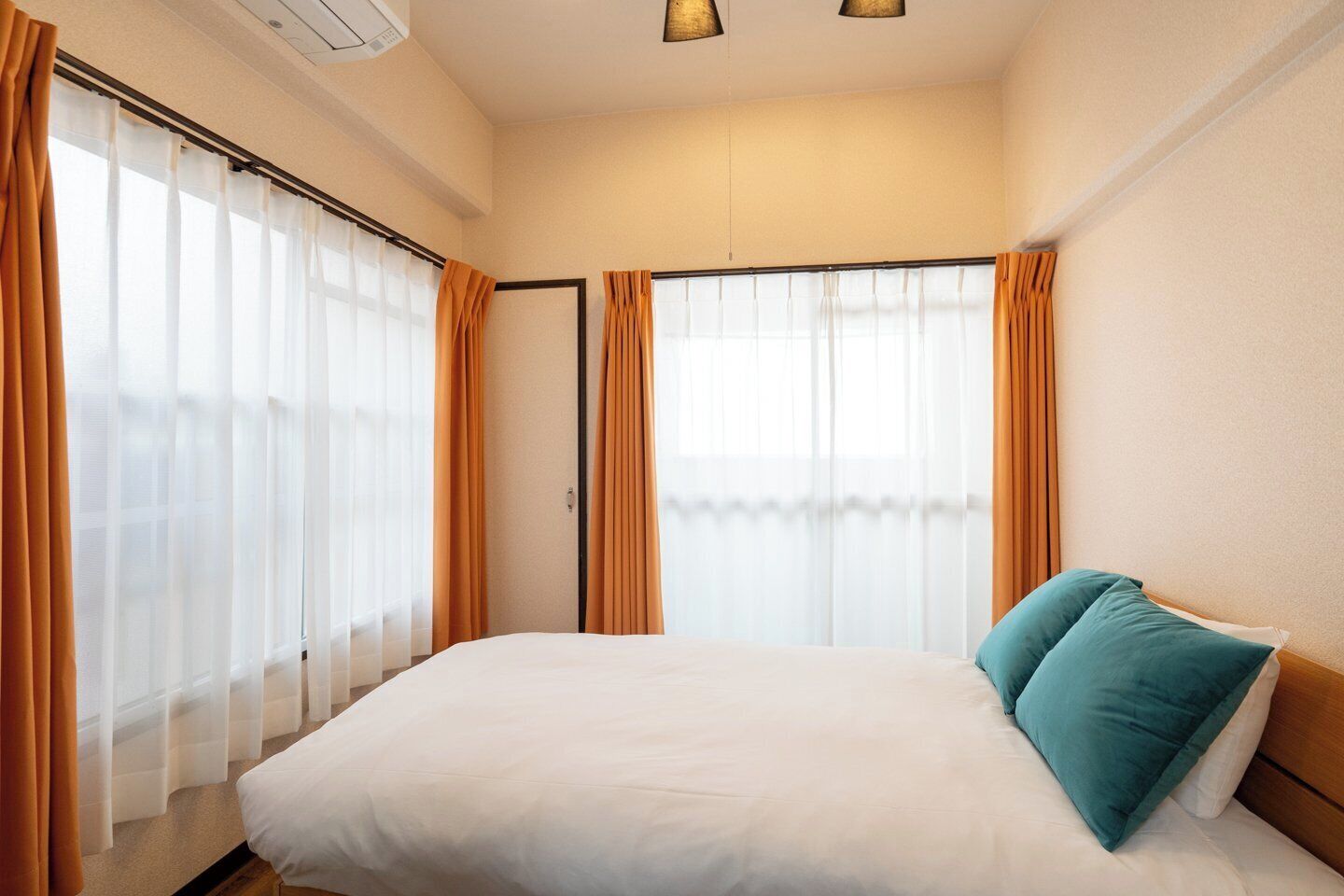 Quarto de hotel com cama, cortinas e janela.