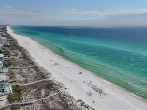 A beach with a clear view of the ocean, a sandy shore, and a building with a pool. - NEW Beach Townhouse-Walk to Beach-Family Friendly (Panama City Beach)