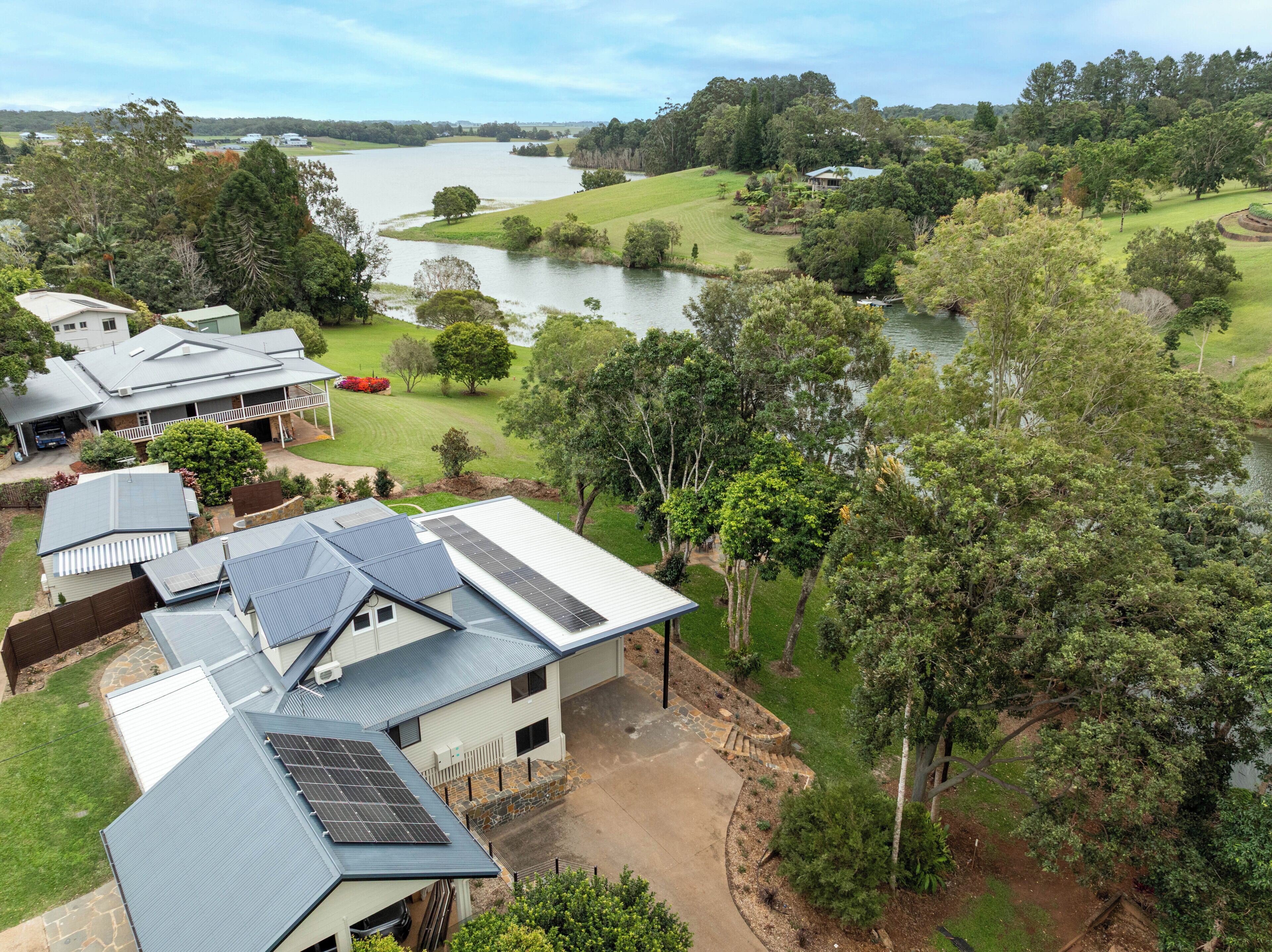 A residential area with houses, a lake, and surrounding greenery.