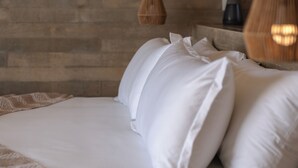 A bed with white linens and pillows, a wooden wall, and two hanging lamps. - Ocean View Luxury Surf Casita 1    
    IG RanchoAguaSal (Playa Tortuga)