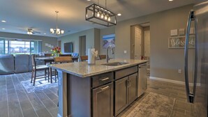 A modern kitchen with granite countertops, stainless steel appliances, and a central island. - Close to Disney! Home w/ Patio & Community Perks (Davenport)