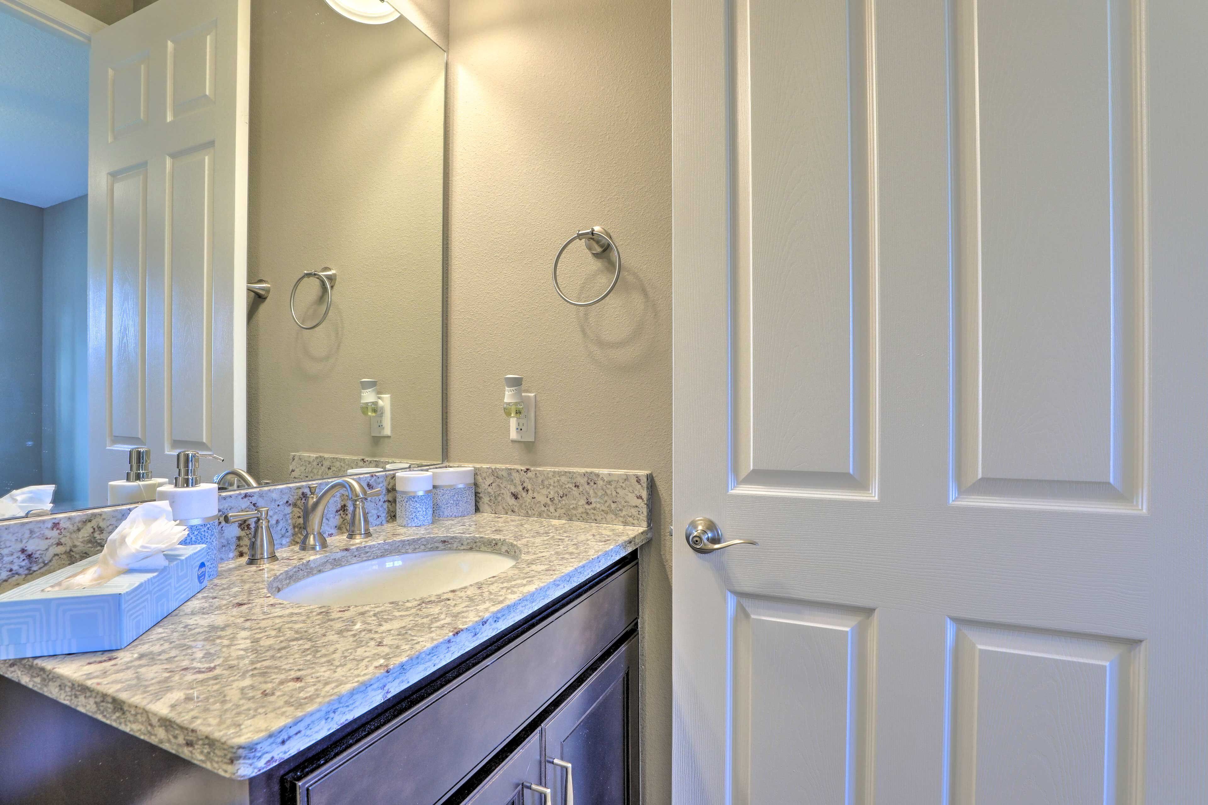 A bathroom with two sinks, a mirror, and a door.
