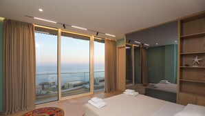 Een moderne hotelkamer met een groot bed, stadszicht en een balkon.