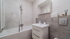 Een moderne badkamer met een bad, een wastafel en een spiegel.