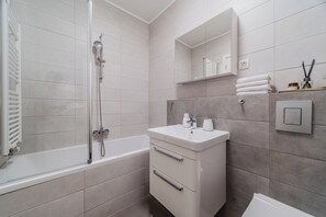 A modern bathroom with a bathtub, a sink, and a mirror. - Meandar Zagreb Apt w/ Garage & Terrace (Zagreb)
